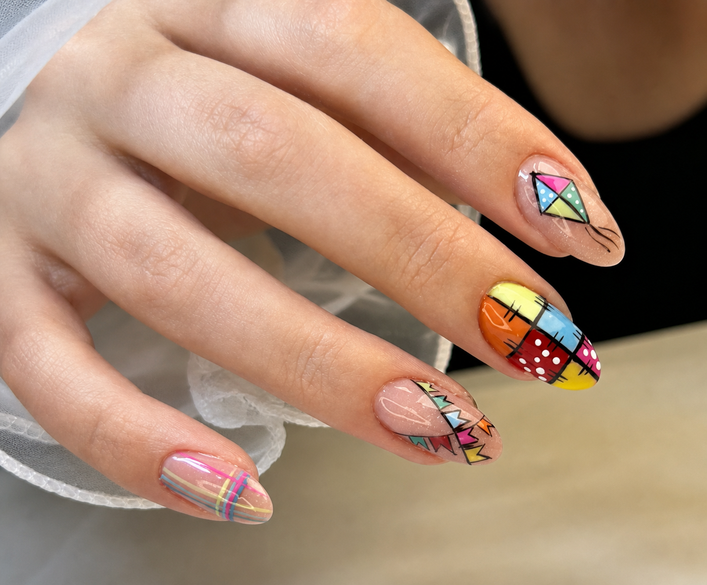 Nail art colorida com desenhos geométricos